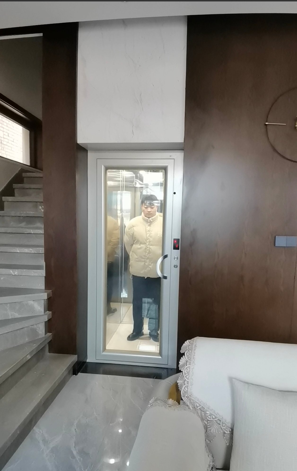上海赫菱简易家用电梯实景，窄框玻璃门安装于别墅楼梯旁